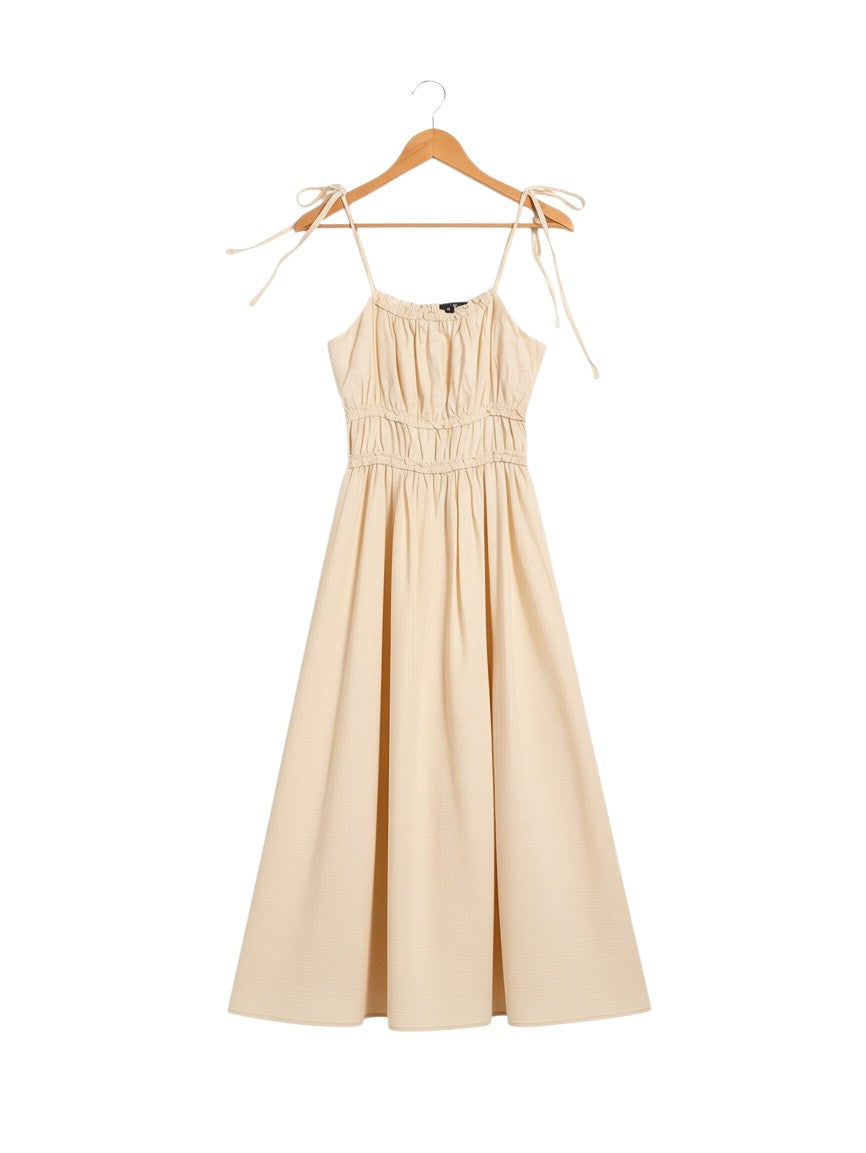 Yanet Collection Shop beige midi dress with spaghetti straps, tie-up shoulders, and a gathered bodice on a hanger.