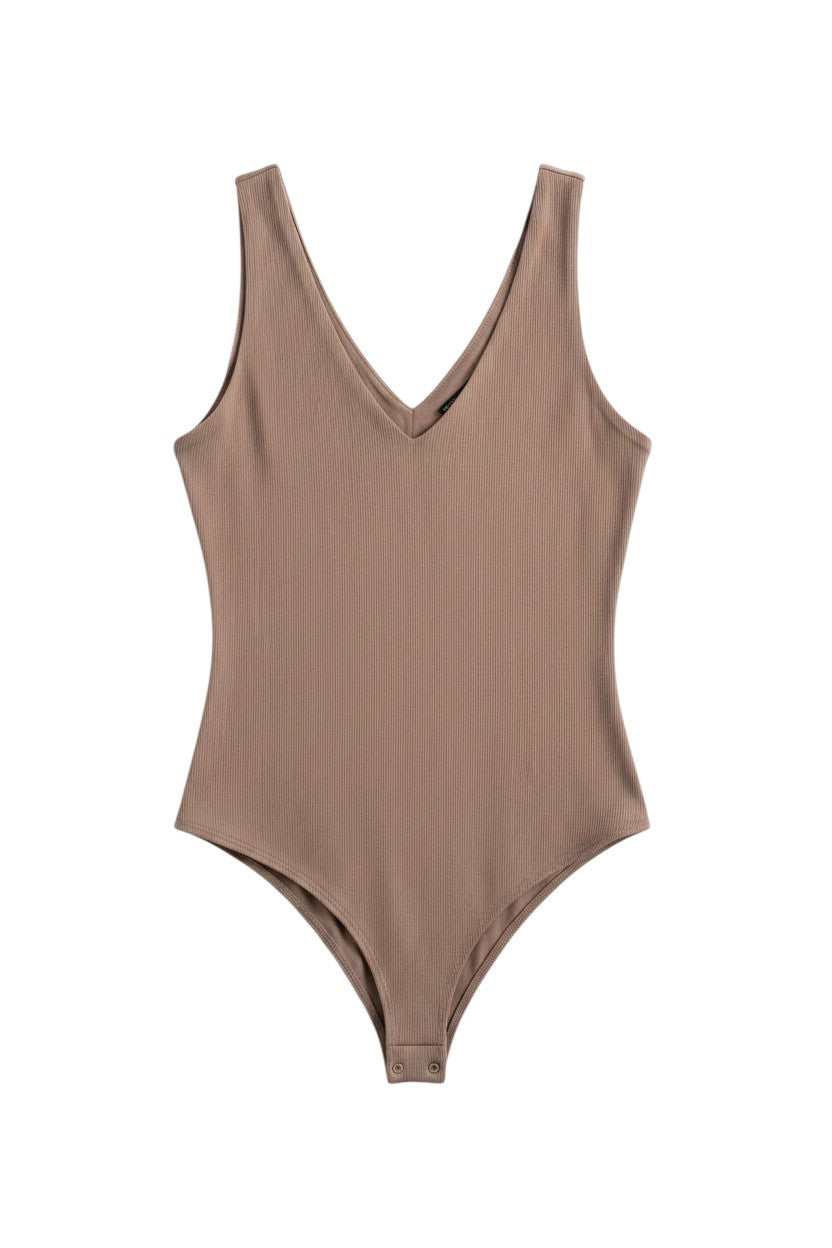 Yanet Collection Shop beige ribbed v-neck sleeveless bodysuit with a fitted silhouette and snap closure.