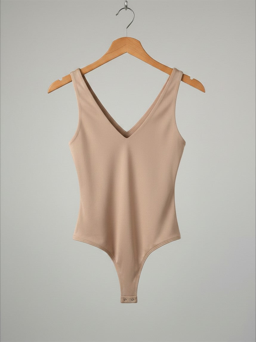 Yanet Collection Shop beige sleeveless v-neck bodysuit in a fitted stretch fabric on a wooden hanger