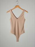 Yanet Collection Shop beige sleeveless v-neck bodysuit in a fitted stretch fabric on a wooden hanger