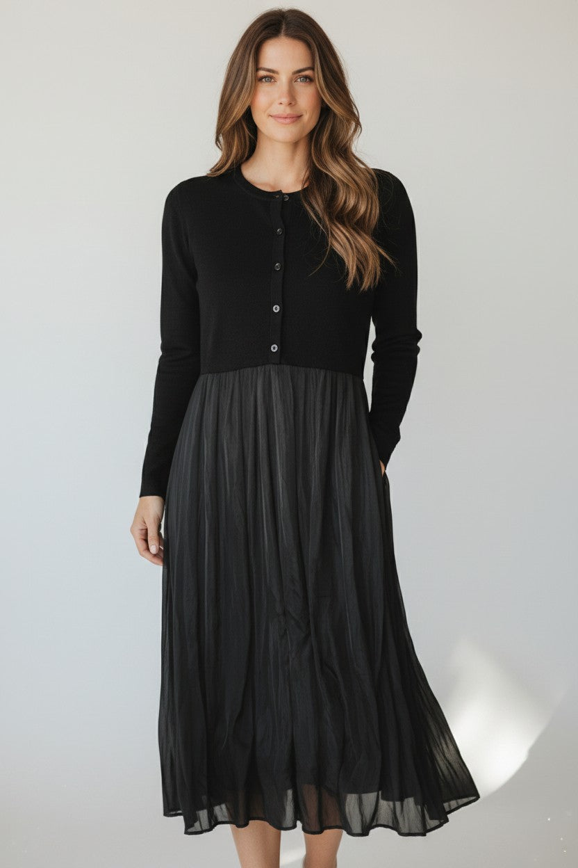 Yanet Collection Shop black long sleeve maxi dress with a button-up fitted bodice and flowing pleated skirt.