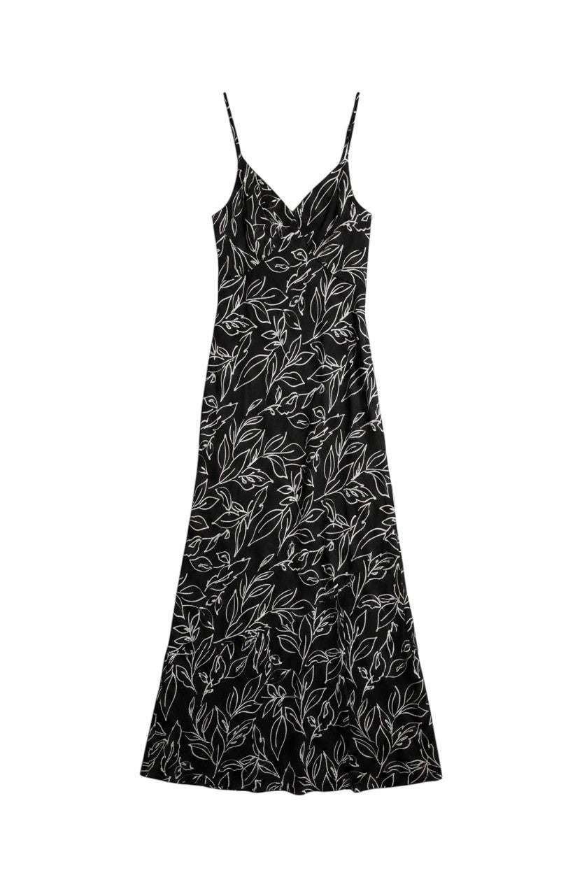Yanet Collection Shop black maxi dress with white line-art floral print, spaghetti straps, and draped silhouette.