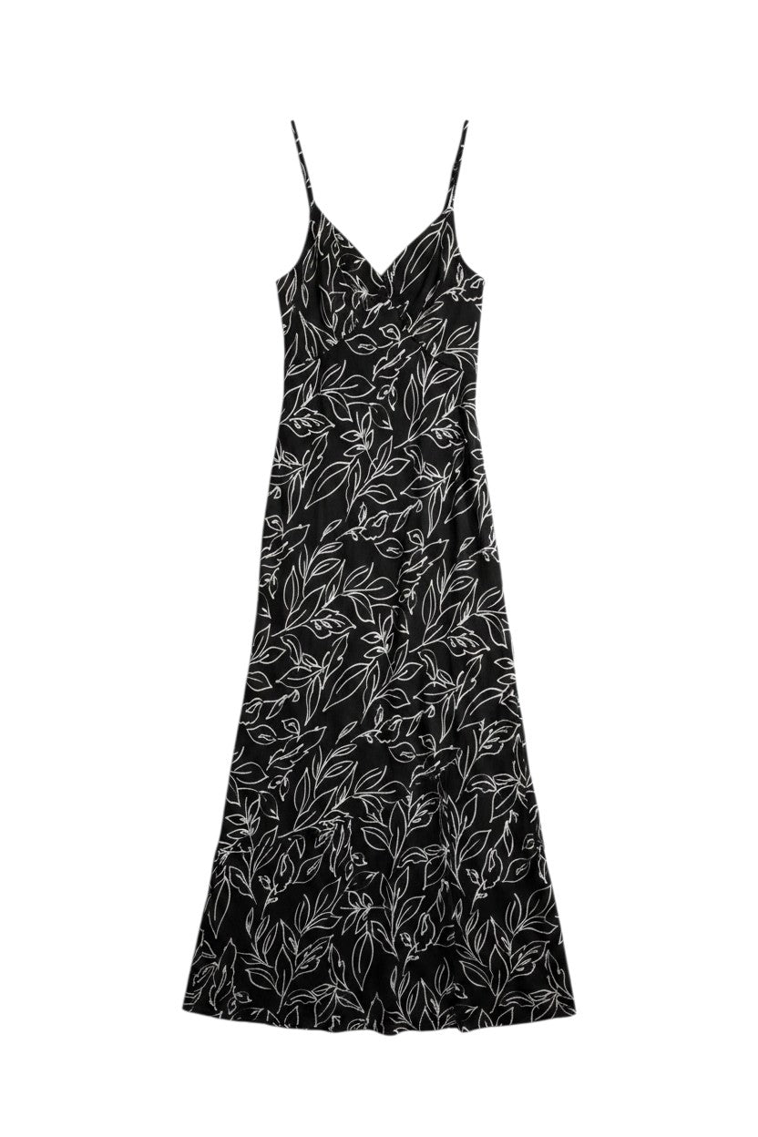 Yanet Collection Shop black maxi dress with white line-art floral print, spaghetti straps, and draped silhouette.