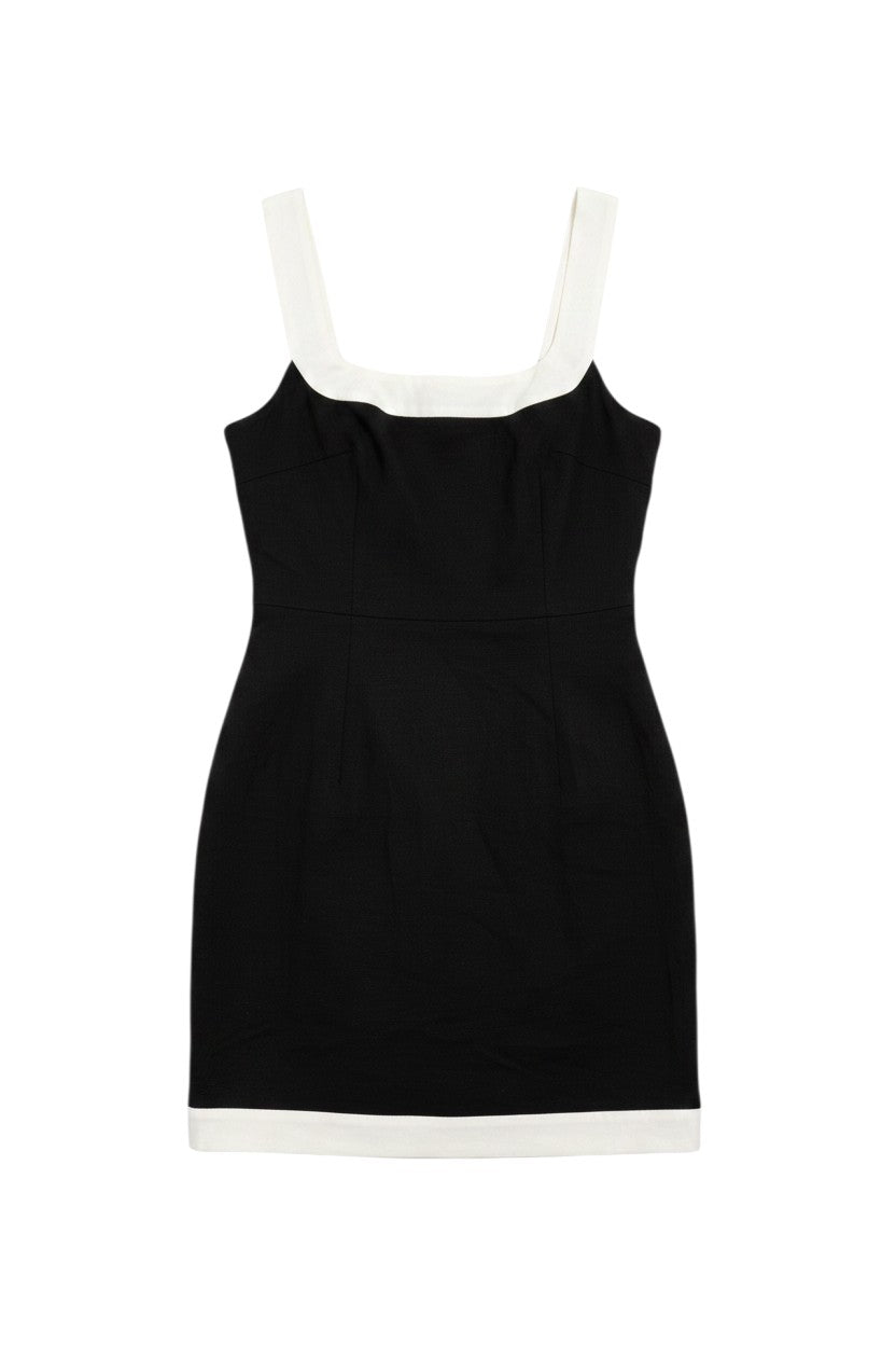 Yanet Collection Shop black sleeveless mini dress with a square neckline and white contrast hem detail.