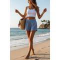 Yanet Collection Shop blue high-waist relaxed shorts with elastic waistband worn by a woman on a sunny beach