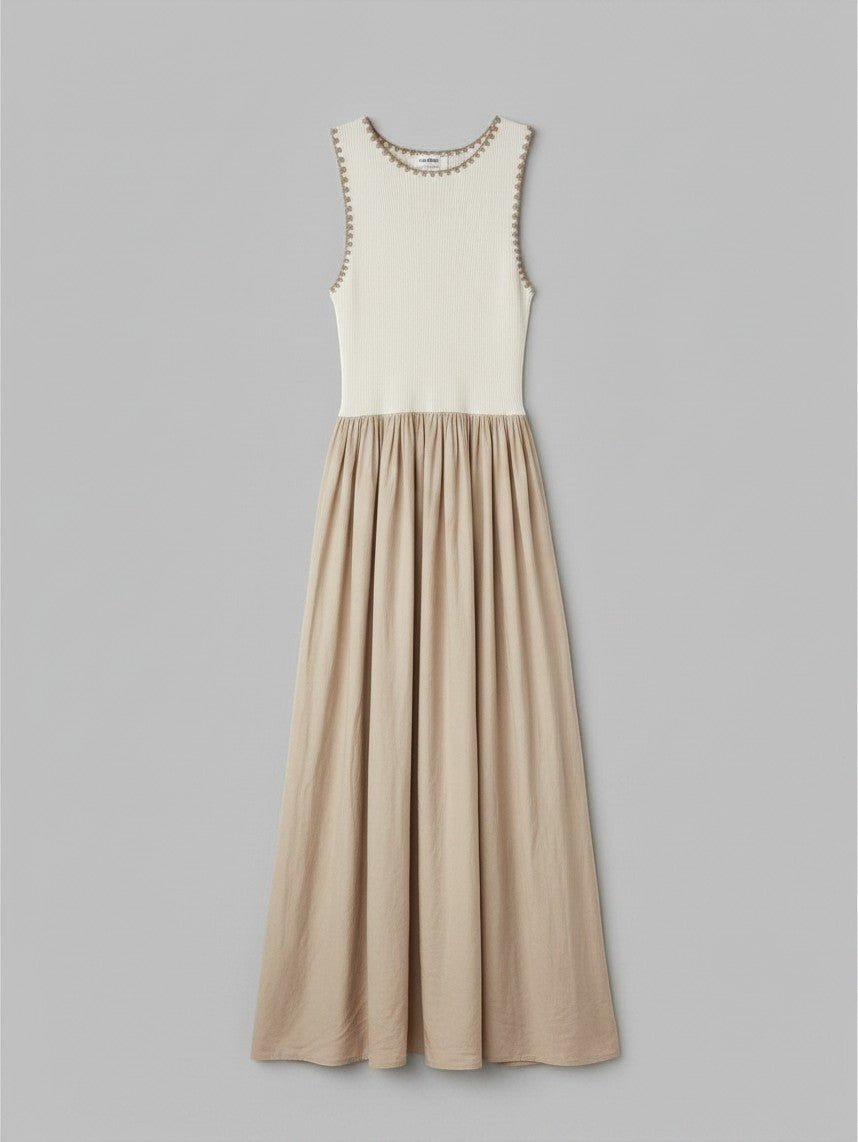 Yanet Collection Shop cream and beige sleeveless maxi dress with a textured bodice and flowy pleated skirt.