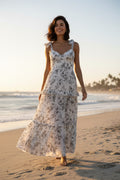 Yanet Collection Shop cream floral maxi dress with ruffled layers, sweetheart neckline, and spaghetti straps on beach