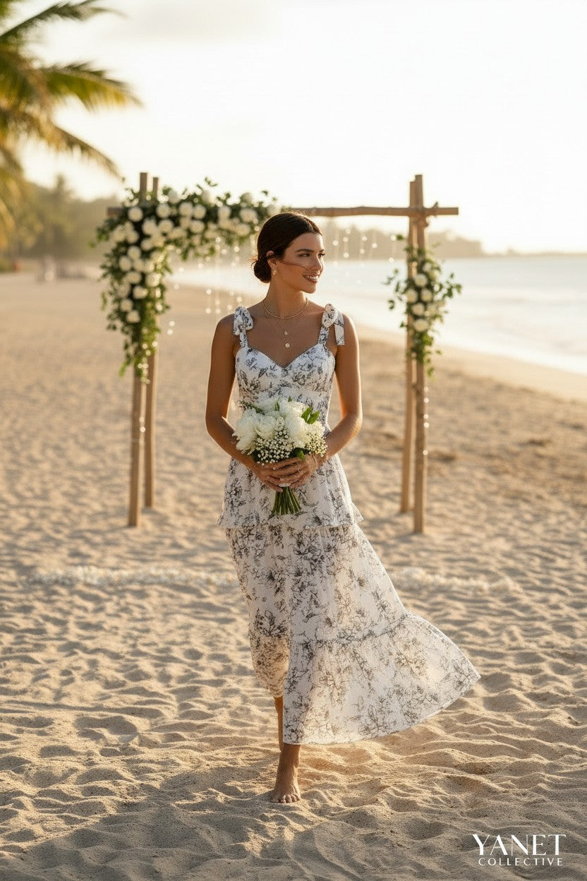 Yanet Collection Shop cream floral maxi dress with ruffled layers, sweetheart neckline, and spaghetti straps on beach