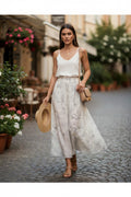 Yanet Collection Shop cream floral print maxi skirt worn by a woman with a white tank top and straw hat on a street