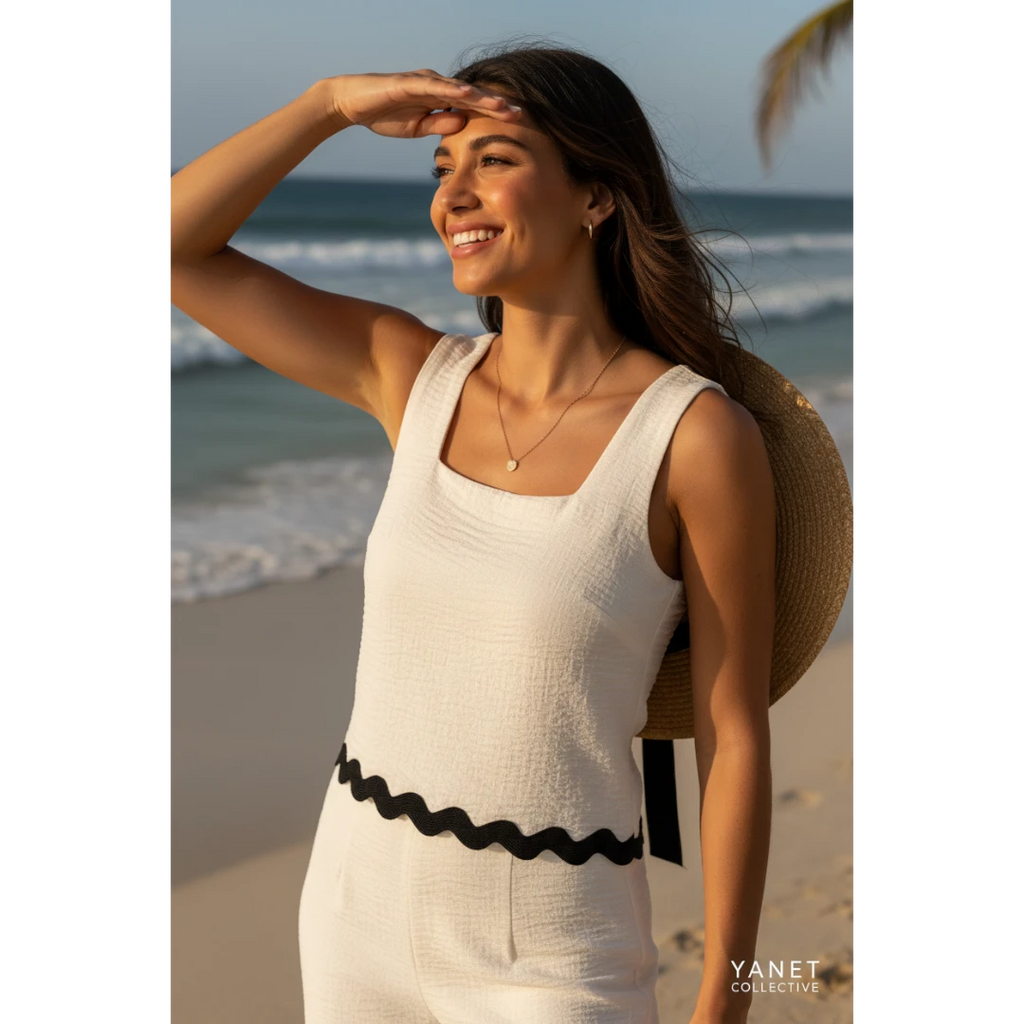 Yanet Collection Shop cream textured square neck crop top with a scalloped hem worn by a woman on a sunny beach.