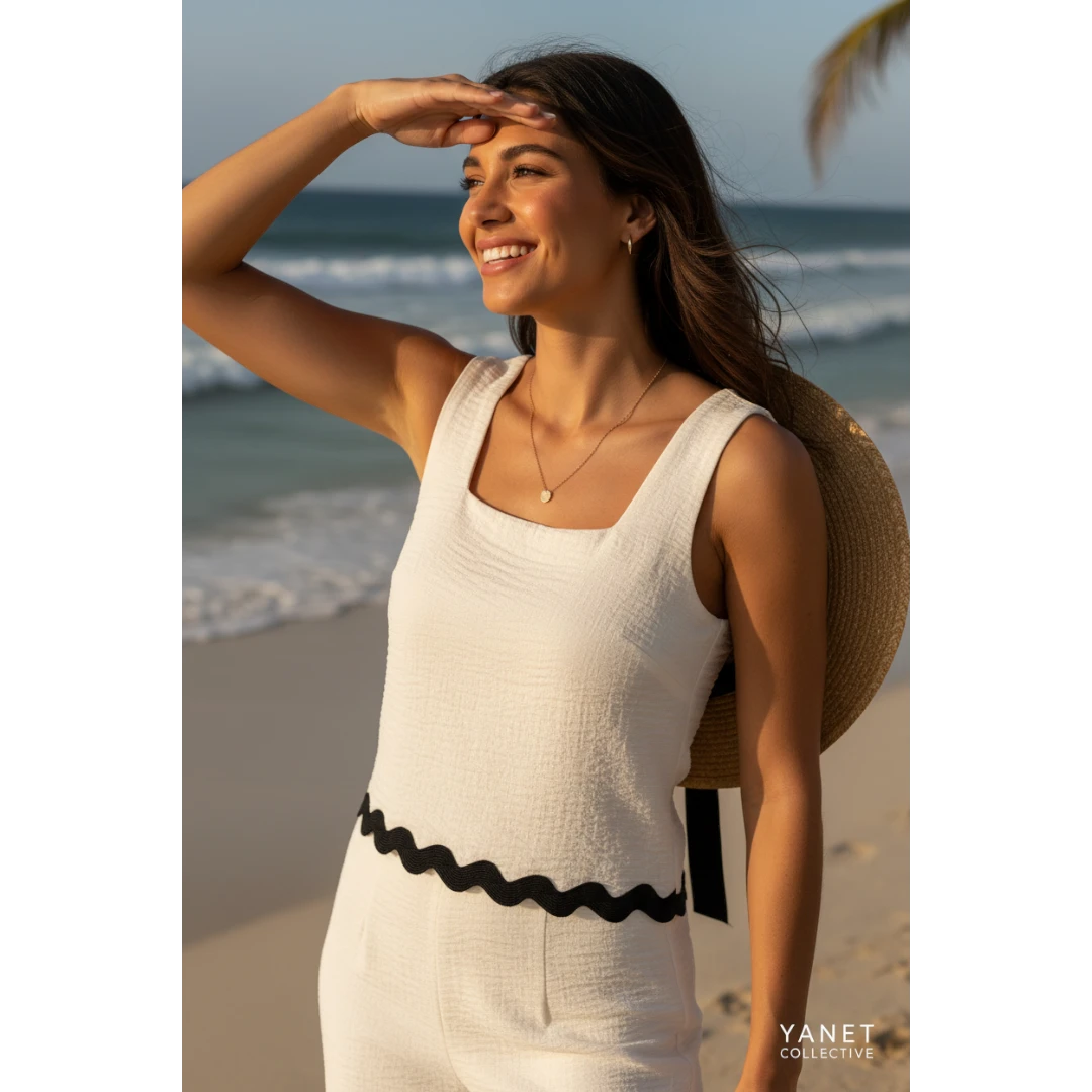 Yanet Collection Shop cream textured square neck crop top with a scalloped hem worn by a woman on a sunny beach.