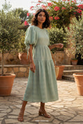 Yanet Collection Shop mint green textured maxi dress with puff sleeves and tie shoulder details in a garden setting