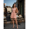 Yanet Collection Shop woman wearing a peach tailored vest and matching shorts with a brown woven handbag at a cafe