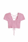 Yanet Collection Shop pink cropped knit top with short sleeves, v-neckline, and lace-up back detail.