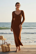 Yanet Collection Shop rust ribbed long-sleeve maxi dress with scoop neckline worn by a model on a beach boardwalk.