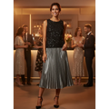Yanet Collection Shop woman wearing a black sequin sleeveless top and a metallic silver pleated midi skirt at a party