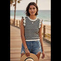 Yanet Collection Shop black and white striped knit top with ruffle sleeves worn by a woman on a beach boardwalk