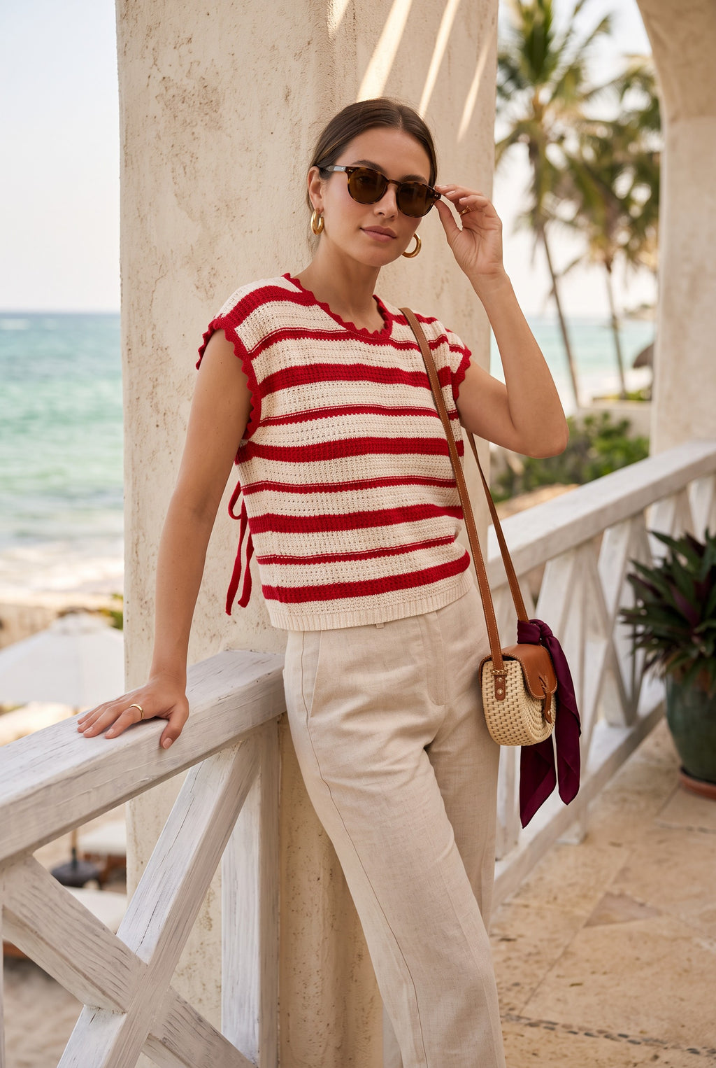 Yanet Collection Shop cream and red striped short sleeve knit sweater with ruffle trim worn by a woman on a balcony